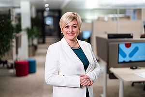 Ein Bild einer Frau mit kurzen, blonden Haaren im weißen Blazer